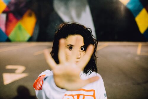 Girl with hand raised in stop gesture